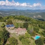 Aerial view of farm, farmhouses, pool and land at Caprese Michelangelo Tuscany Italy