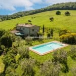 View showing restored farmhouse home, garden, pool and surroundings Monticchiello Pienza Tuscany Italy