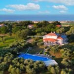 Aerial view of recently built luxury villa, gardens, pool and sea view. Senigallia Marche Italy