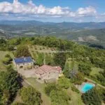Aerial view of farm, farmhouses, pool and land at Caprese Michelangelo Tuscany Italy