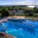 View of vacation resort pool, buildings and Lake Trasimeno