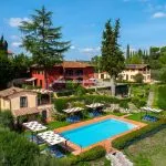 View of pool, villa, farmhouse and restored barn Cetaldo Florence Tuscany Italy
