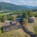 Aerial view of fixer upper farmhouse and barn in Umbria
