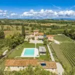 Aerial view of Tuscan farmhouse with guesthouses, garden and swimming pool
