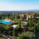 View of the agriturismo buildings and pool of the organic olive oil farm for sale in Tuscany